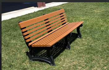 Brown recycled-plastic park bench with black frame installed on a lawn in Summit County, Utah